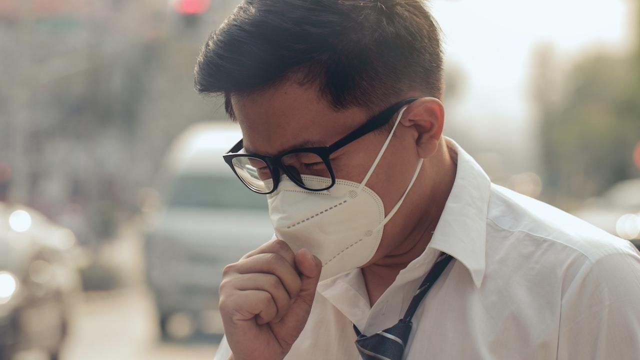 Hombre en calle con contaminación por el tráfico
