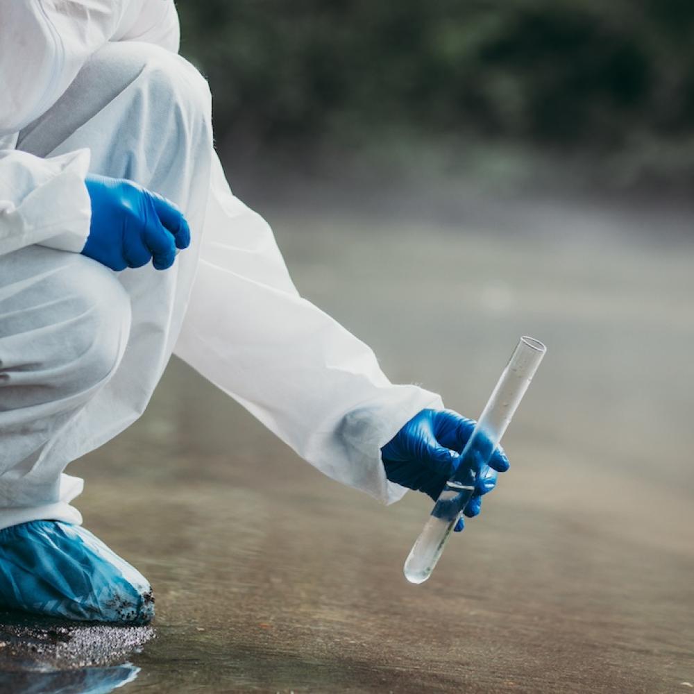 persona realizando un análisis de agua en un río