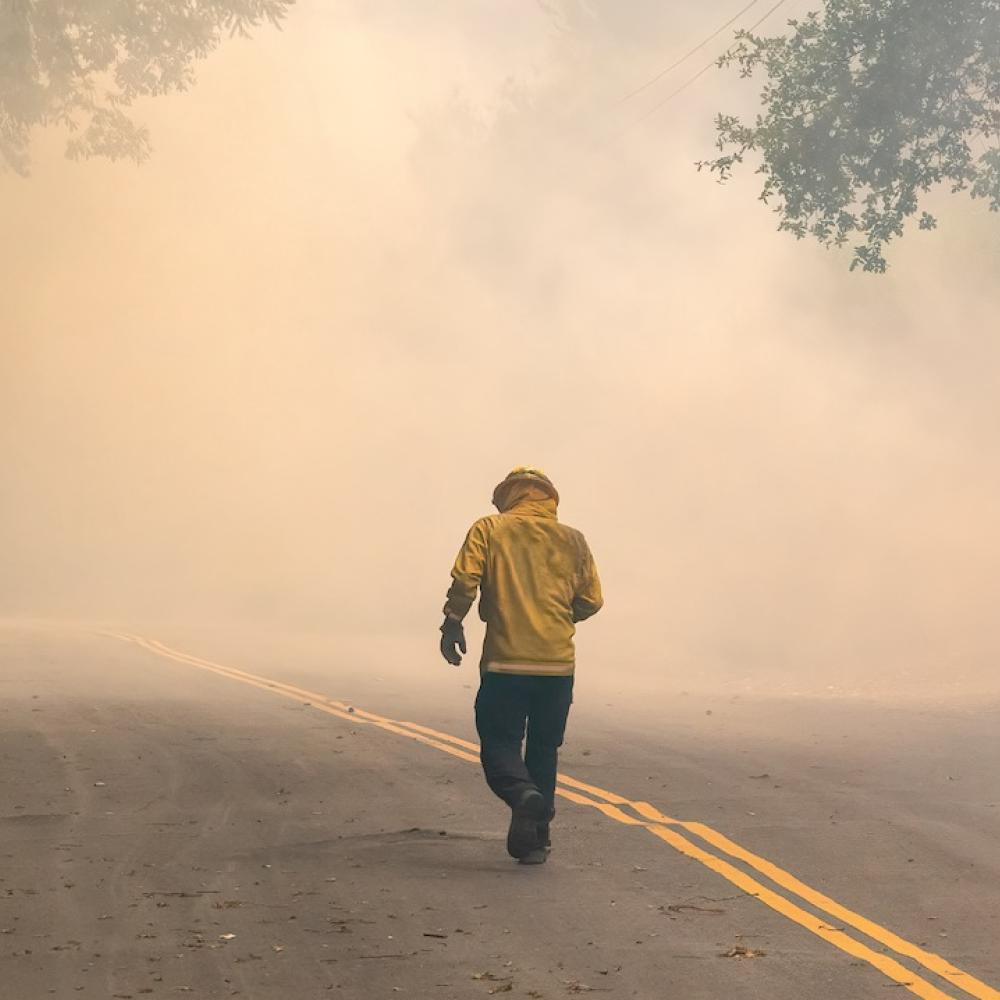 Bombero caminando en zona de incendio con humo